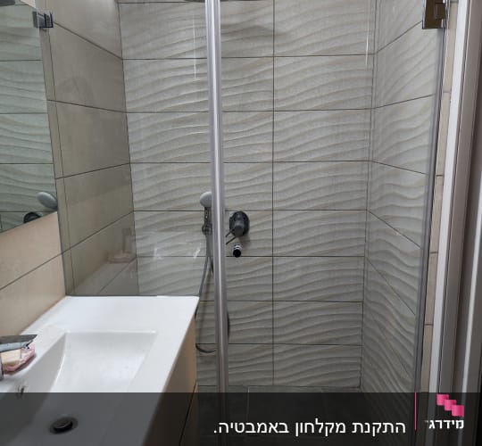 מקלחון עם דלת זכוכית וראש מקלחת עגול